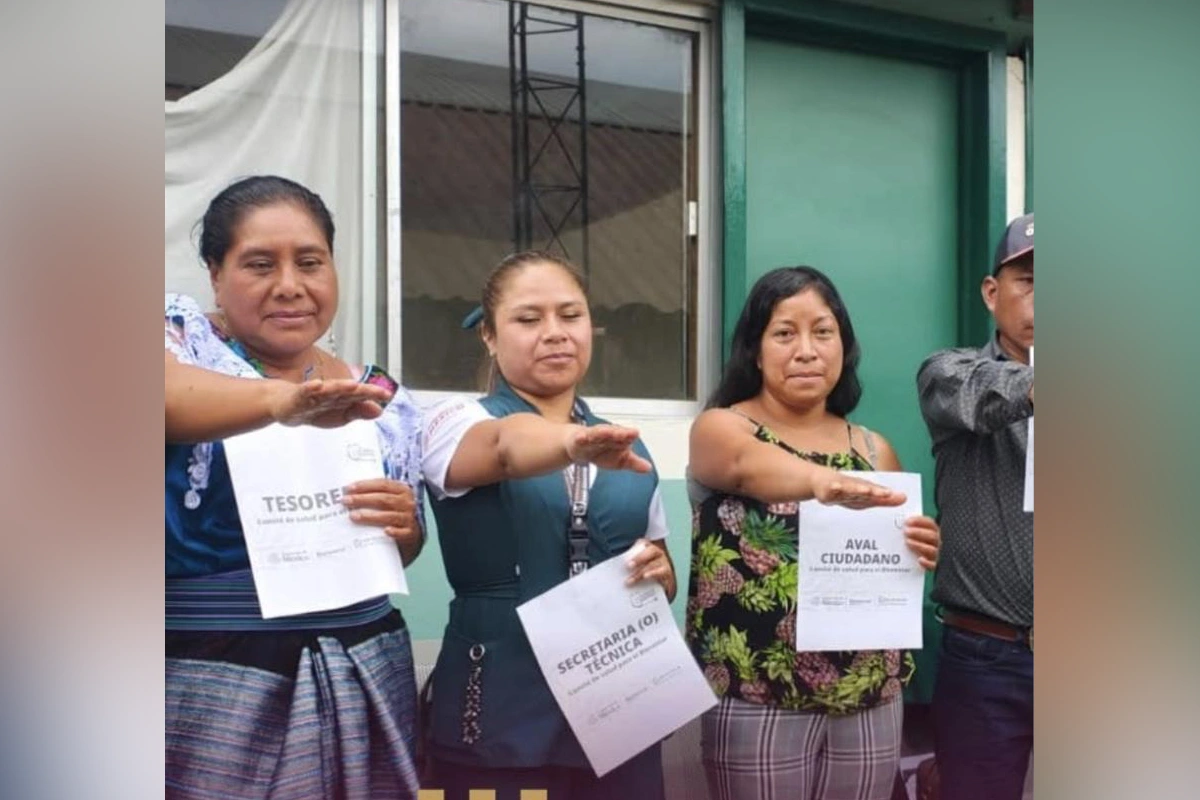 Miembros comunitarios rinden protesta como integrantes del Comité de Salud para el Bienestar sosteniendo nombramientos de tesorera, secretaría técnica y aval ciudadano.